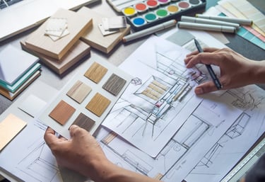 a person is working on a design project with drawings and materials samples