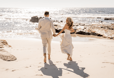 newlywed couple running on the beach in La Jolla , California