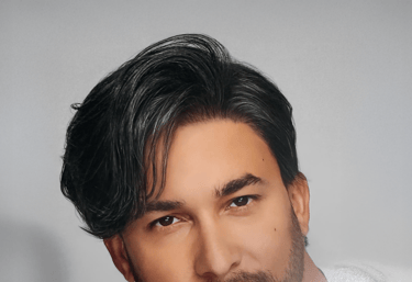 Homme aux cheveux noirs coiffés sur le côté avec une coupe moderne et structurée.