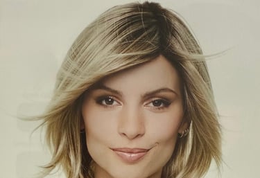 Femme aux cheveux blonds coiffés en dégradé avec une frange balayée.