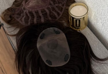 Toppers capillaires bruns posés sur une table à côté d’un photophore doré.