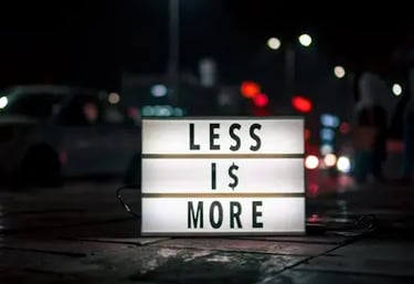 Lightbox with “Less is More” sign on a city street, symbolizing Binance’s low trading fees and extra