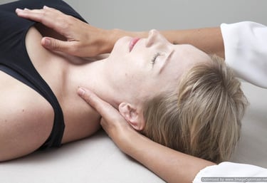 a woman lying down receiving gentle, listening touch in a craniosacral therapy session