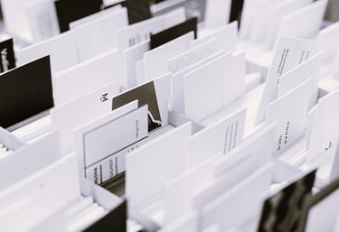 Photo en noir et blanc de plusieurs cartes de visite et supports triés