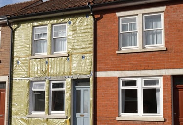 A modern building undergoing eco-friendly retrofitting with scaffolding and green materials.