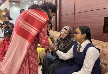 An image of Shruti communicating with deaf blind student Sarah Moin by writing on her hand.