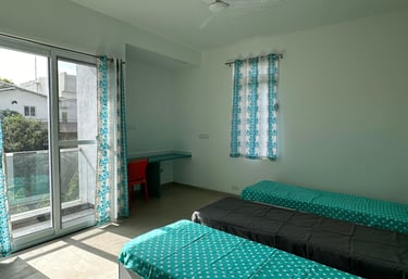 Spacious twin-sharing PG room in Banglore with a balcony, modern furniture, A/C and luxury.