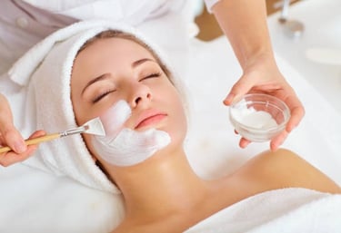 a woman getting a facial mask with a brush