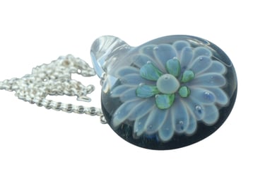 a glass pendant necklace with a flower on it
