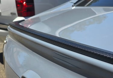 Custom vinyl wrap on rear spoiler, showcasing aesthetic detail and quality finish by Bluemax Tint.