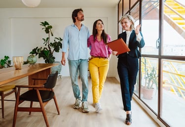 a man and woman walking through a room with a laptop