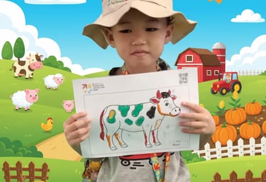 Child holding colored drawing template for Color to Life interactive game at kids event in Indonesia
