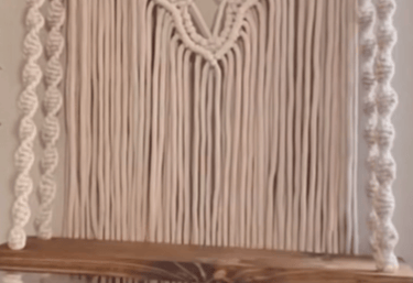a macrame hanging from a wooden shelf