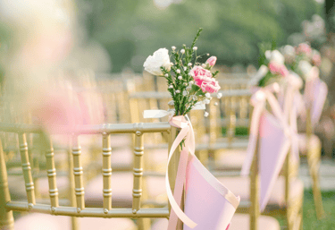 vidéaste de mariage professionnel pas cher peu cher a row of chairs with pink ribbon tied to them