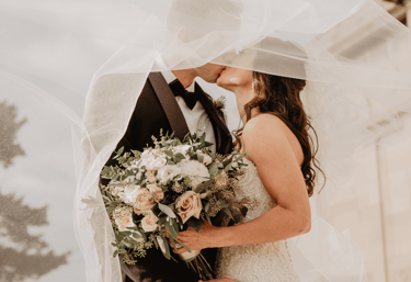 a bride and groom kissing in front of a church