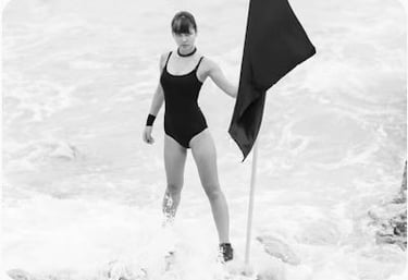 woman in black one piece swimsuit holding umbrella