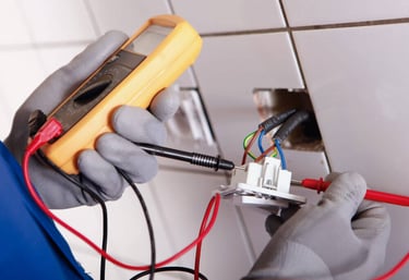 a person in gloves and gloves holding a multimetered device