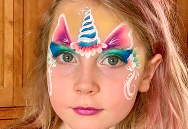 Girl with pretty unicorn face painting. 