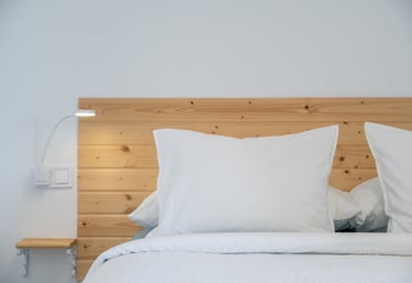 a bed with a wooden headboard and a lamp
