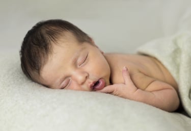 Sessió de fotos newborn a Girona amb una bebè recent nascuda dormint en estudi fotogràfic