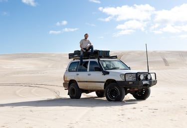 persoon zit op een 4x4 Toyota Lancruiser in de woestijn in West Australie
