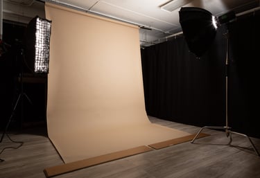a photo studio with a tan seamless backdrop paper rolled out