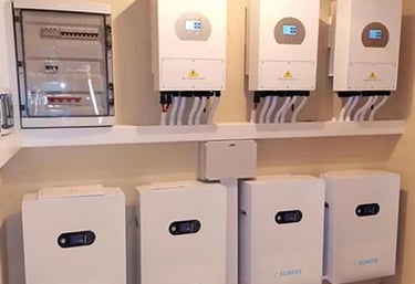 Residential solar energy system featuring wall-mounted hybrid inverters and lithium battery storage units.