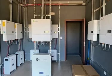 Professional solar power installation featuring multiple hybrid inverters and lithium battery storage units.