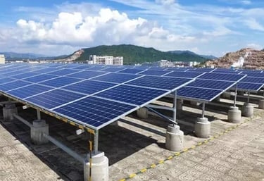 A rooftop solar panel installation for renewable energy on an industrial building with a mountain view.