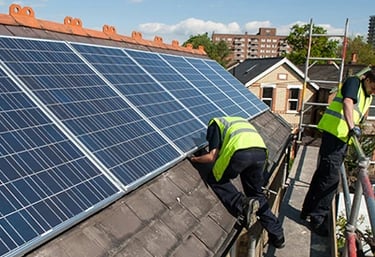Professional contractors installing solar panels on a residential rooftop for renewable energy.