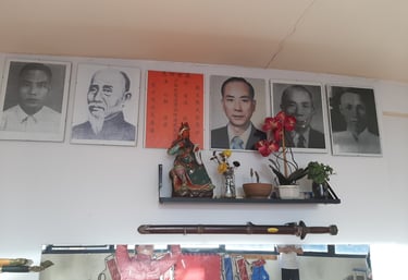 Altar de los maestros de kung fu. Una estatuilla de Guan Gong y pequeñas macetas con flores.