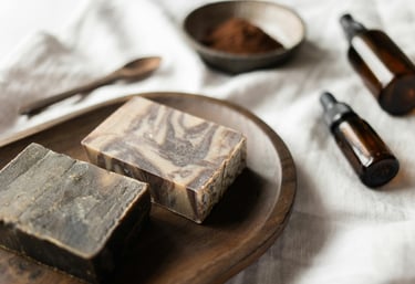 Handcrafted goat milk soap bars on a wooden dish with natural ingredients and essential oils