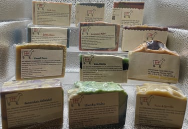 Display of assorted handmade goat milk soaps from Pagnotta Family Farm, featuring a variety of natural scents and colors.