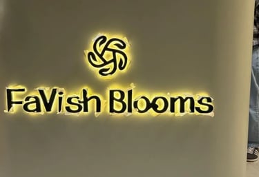 Illuminated FaVish Blooms back-lit channel letter office signage being installed on a curved wall.