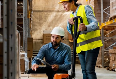 Dois homens em manuseando uma paleteira manual