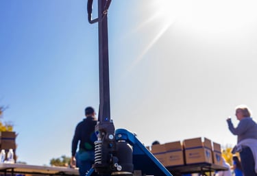 uma paleteira azul com um homem em pé ao lado dela
