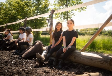 a group of kids sitting in horse ranch