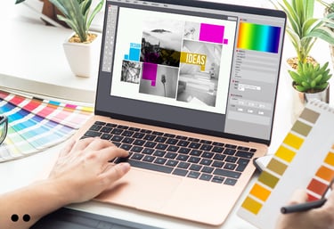 Designer working on laptop, selecting colors and creating graphic layouts for branding and marketing