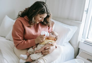 a woman breastfeeding a baby in a bed