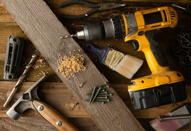 une perceuse avec des outils sur du  bois symbolisant la réparation