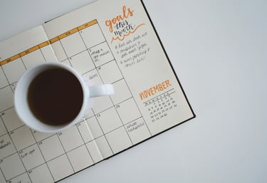 Mug with coffee on top of a calendar