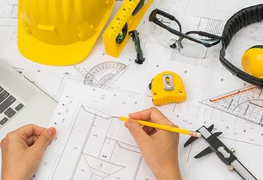 a person is working on a laptop computer and a yellow helmet