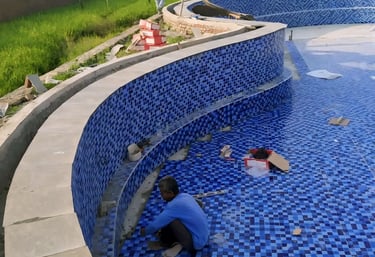 perapihan nat keramik kolam renanag berwarna biru.