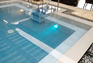 Desain kolam renang air hangat modern dengan air terjun buatan di Purwakarta.