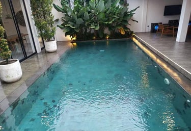 kolam renang minimalis di halamn belakang rumah dengan finishing batu alam