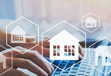 a person typing on a laptop computer with a house in the background