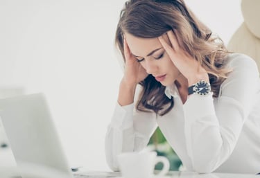une femme qui se tient la tête car elle a une migraine