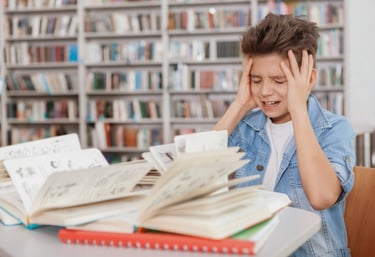 a boy is sitting at a table with a book and a book