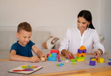 a woman and a boy playing with blocks