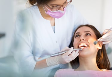 A dentist examining a patient’s teeth with advanced dental equipment in a clinic.